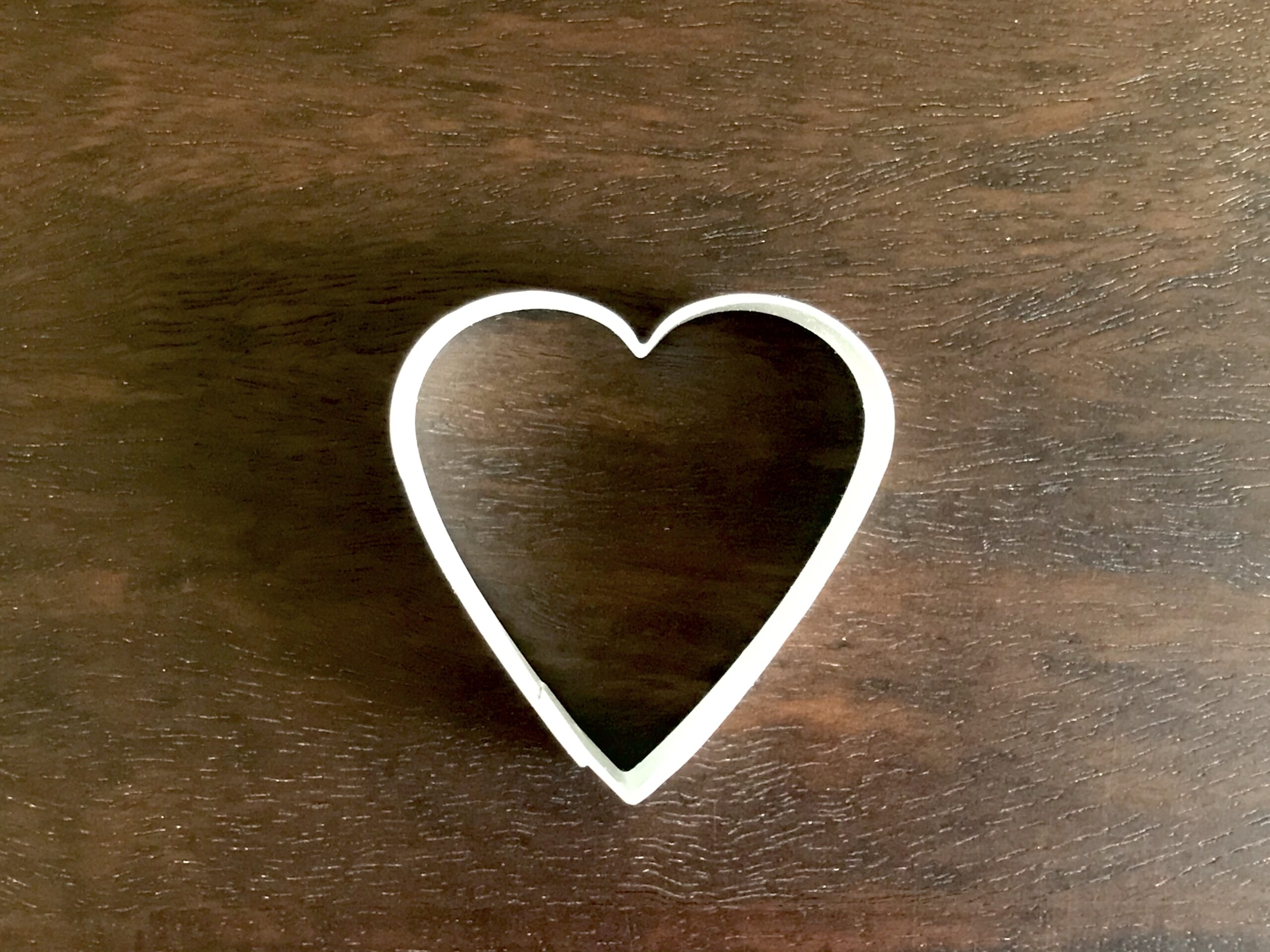 heart cookie cutter on dark wood background