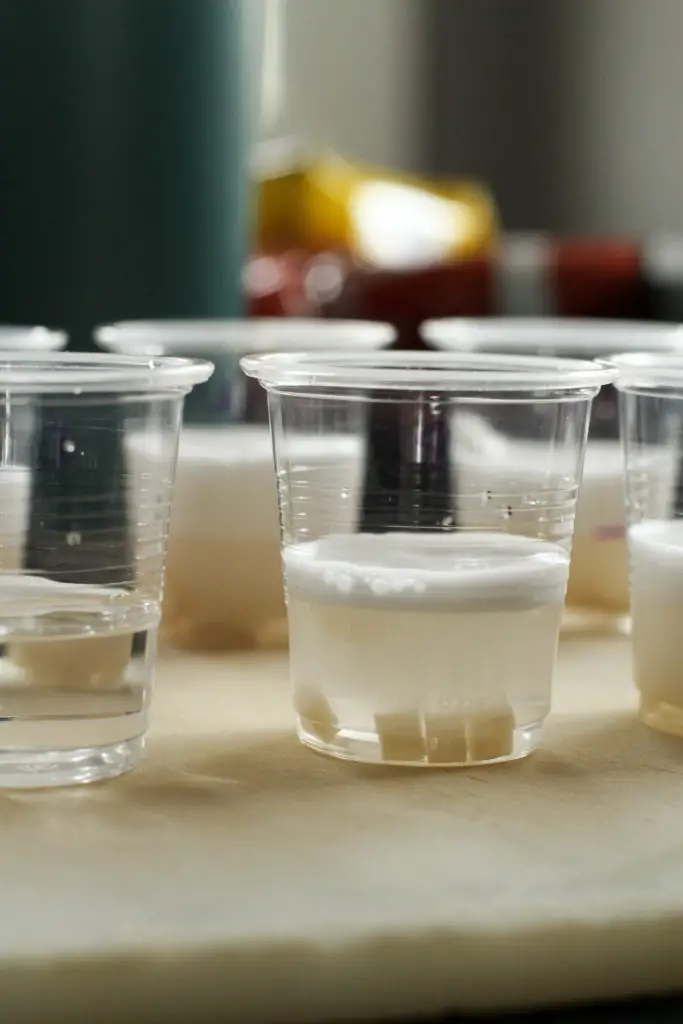 Potato cubes in clear plastic cups.