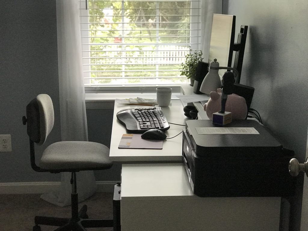 A white desk by a window.