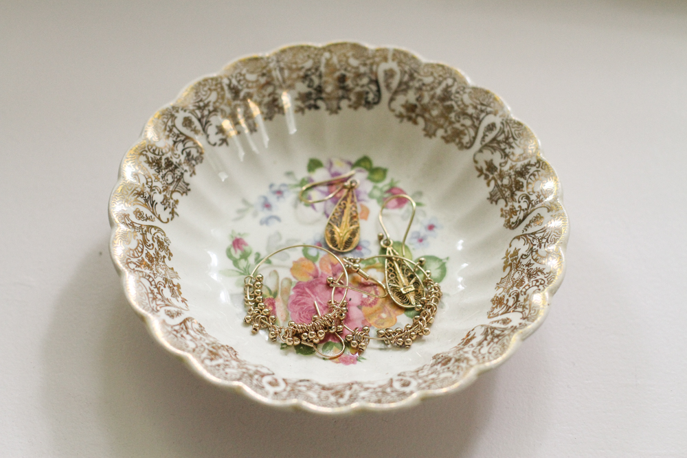 floral bowl holding gold earrings.